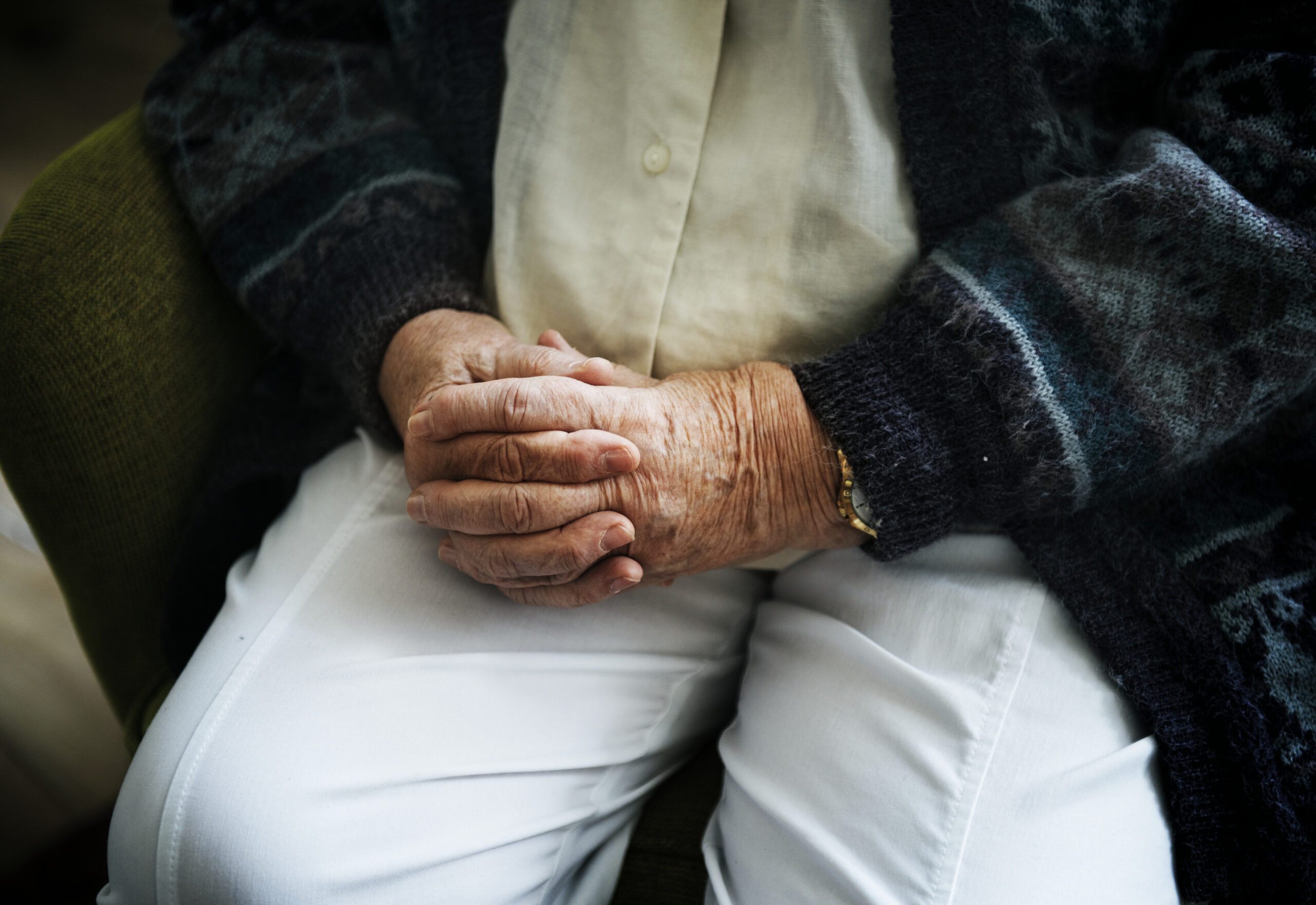 Sitting senior man close up on his holding hands