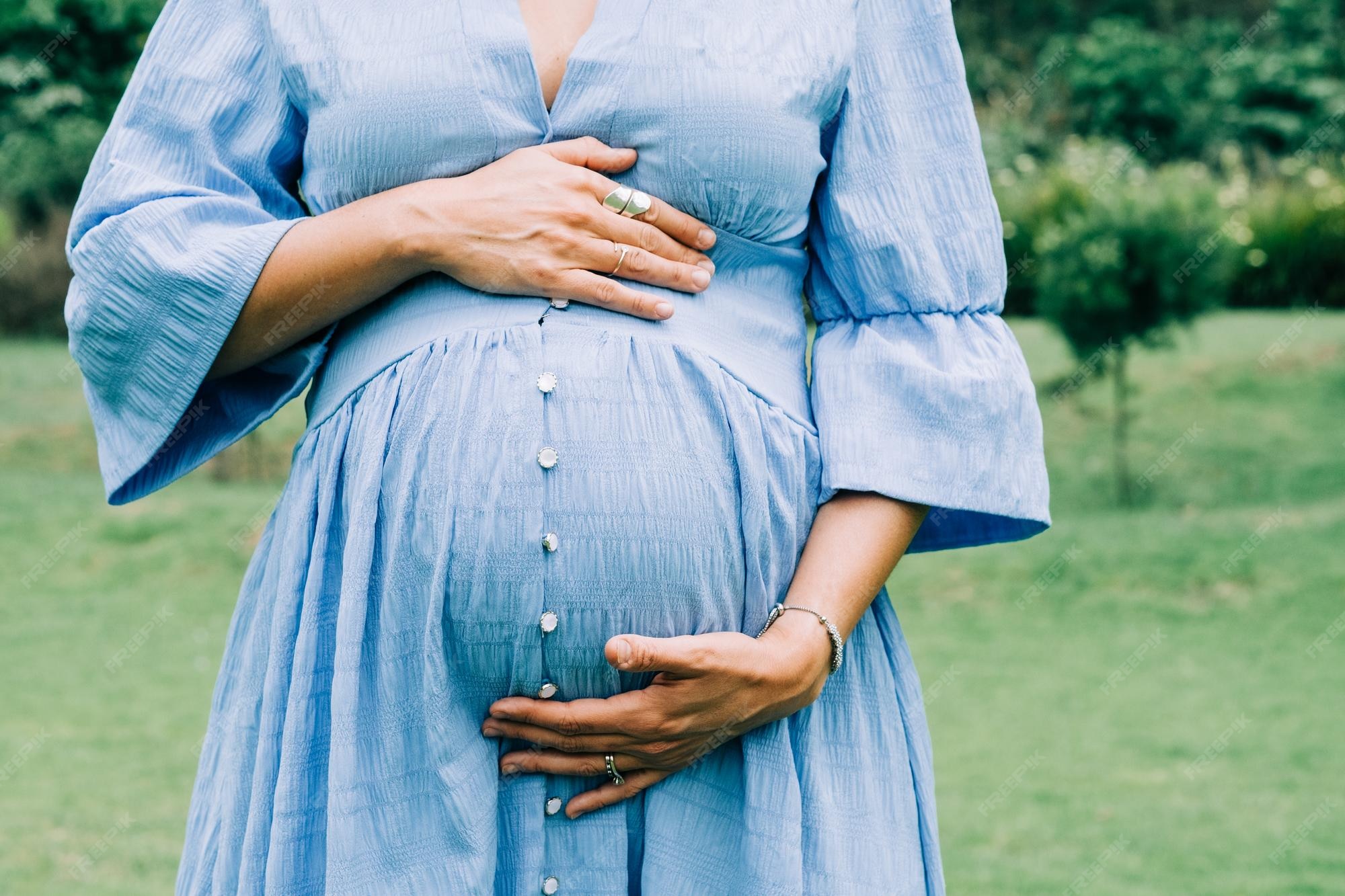 close-up-unrecognizable-pregnant-woman-holding-her-belly_1048944-26594151